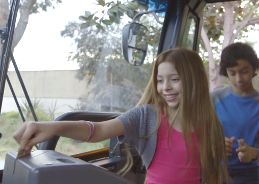 Young girl paying with a card while getting on the bus